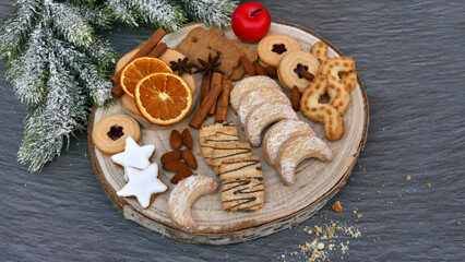 Eine Auswahl an Weihnachtsgebäck auf einer Holzscheibe.