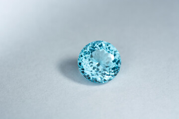 Deep sky blue colored topaz or swiss blue topaz gemstone setting on light gray background position...