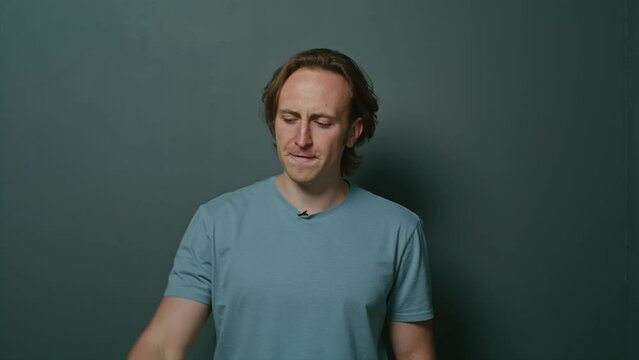 Guy with long hair indignant and says something. Man with headache and experiences. Serious, angry, and neutral facial expressions. active gesticulation. emotional movements.