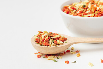Mixed pieces of dried vegetables  in wooden spoon with copy space and white background