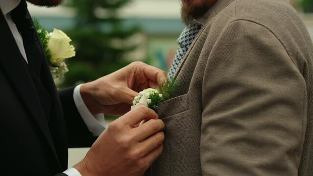 Groom puts on best man's white bouquet