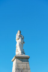 Fototapeta premium single caring woman statue against a bright blue sky