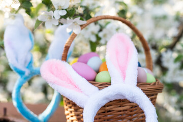 a basket with painted eggs and rabbit ears, Easter