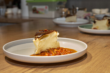 Piece of cheesecake with sea buckthorn jam on a plate