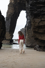 Girl on Playa de Las Catedrales (Beach of the Cathedrals) in Galicia, Spain.