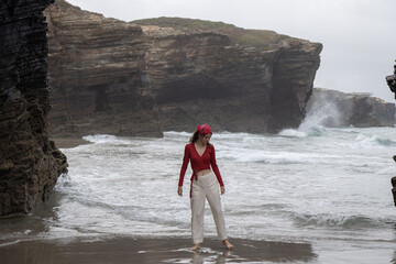 Girl on Playa de Las Catedrales (Beach of the Cathedrals) in Galicia, Spain.