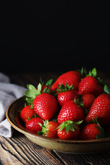 A bowl with ripe bright strawberry in rustic style