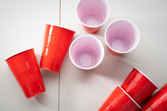 Red Plastic Party Cups on a White Folding Table Surface