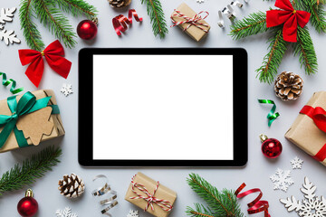 Fototapeta na wymiar Digital tablet mock up with rustic Christmas decorations for app presentation top view with empty space for you design. Christmas online shopping concept. Tablet with copy space on colored background