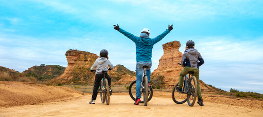 Happy family with mountain bike ( Monegros desert,  Huesca province in Spain)