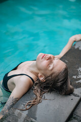 Beautiful girl enjoy in swimming pool with closed eyes. Close up