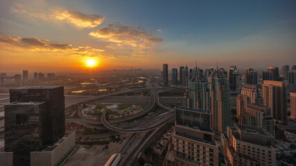 Naklejka na ściany i meble Sunrise over Dubai marina and JLT skyscrapers along Sheikh Zayed Road aerial timelapse.
