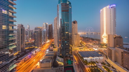 Panoramic view of the Dubai Marina and JBR area and the famous Ferris Wheel aerial night to day timelapse