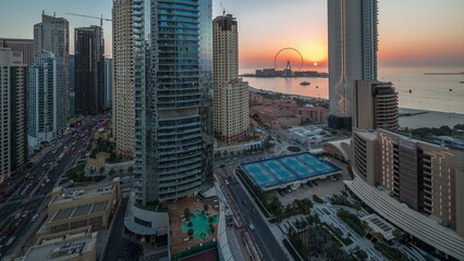 Panoramic view of the Dubai Marina and JBR area and the famous Ferris Wheel aerial day to night timelapse