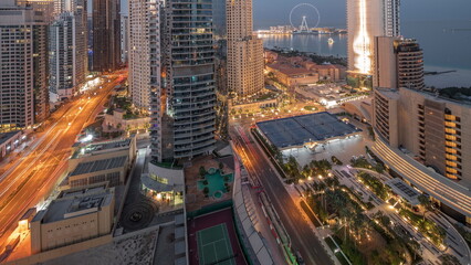 Fototapeta na wymiar Panoramic view of the Dubai Marina and JBR area and the famous Ferris Wheel aerial night to day timelapse