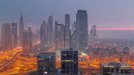 Panorama of Dubai Financial Center district with tall skyscrapers with illumination night to day...