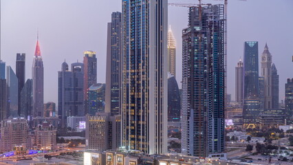 Obraz premium Row of the tall buildings around Sheikh Zayed Road and DIFC district aerial day to night timelapse in Dubai