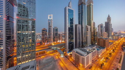 Aerial view of Dubai International Financial District with many skyscrapers night to day timelapse.