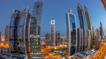 Obraz premium Aerial view of Dubai International Financial District with many skyscrapers night to day timelapse.