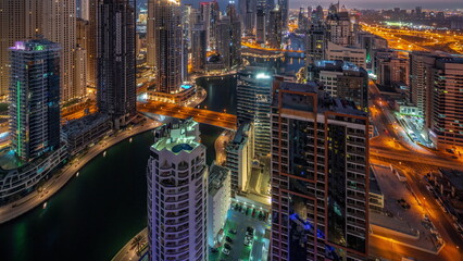 Naklejka premium View of various skyscrapers in tallest recidential block in Dubai Marina aerial night to day timelapse