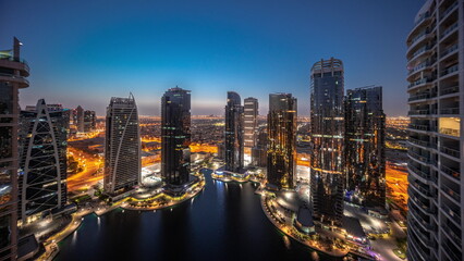 Fototapeta na wymiar Tall residential buildings at JLT aerial night to day timelapse, part of the Dubai multi commodities centre mixed-use district.