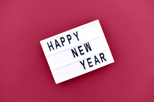 Lightbox on a magenta background with the inscription happy new year. - Powered by Adobe