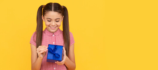 happy kid hold gift box on yellow background, present. Child with birthday gift, horizontal poster....