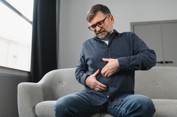 Senior gentleman suffering from pain in bedroom