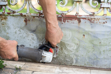Handyman scrape the old paint from rusty fence