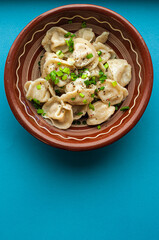 a classic traditional dish of pelmeni dumplings with meat, butter, pepper and greens, food of the countries of the world, gastrotourism