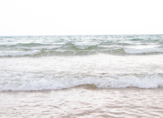 Beautiful wave soft blue ocean wave on clean sandy beach. Clean sand surfing at Thailand. Summer day and sandy beach background concept. Waves sea crashing shore texture Background. Close up no people