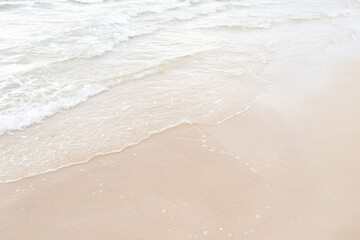 Beautiful wave soft blue ocean wave on clean sandy beach. Close up no people. Clean sand surfing at Thailand. Summer day and sandy beach background concept. Waves sea crashing shore texture Background