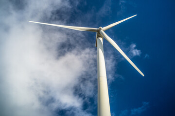 wind turbine close-up view from below against blue sky. Wind power plant. Renewable energy