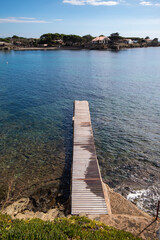 Camino con tablones de madera sobre el mar del pueblo de Cadaqués por donde bajan los turistas de...
