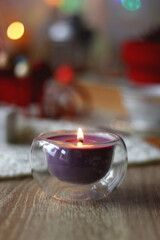 Various colorful Christmas decorations, soft blanket, cup of tea, sweet snacks and lit candles on the table. Cozy Christmas atmosphere at home. Selective focus.