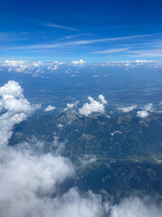 Stunning view of the expanse of land and sky, shot from thousand feet above the ground among white clouds. Smartphone photography