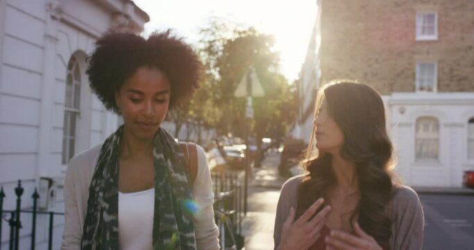 Friends, Women And Walking On City Street For Conversation, Talking And Gossip While Together On A Neighborhood Sidewalk. Females On Urban Road For Travel In Manhattan With Lens Flare In Summer