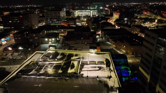 Drone flying over downtown buildings at night