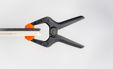 isolated black nylon and reinforced plastic clamp with high tensile steel  spring and orange jaws...