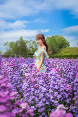 woman wearing a long dress in a field of margaret flowers exudes a relaxed and freedom. Soft and select focus