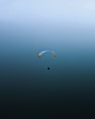 a paraglider flies across the blue sky. Minimalist photography