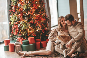 Candid authentic happy married couple spends time together with japanese dog at Xmas lodge