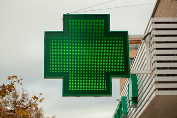 luminous green cross indicating that a pharmacy remains open in the city of Madrid