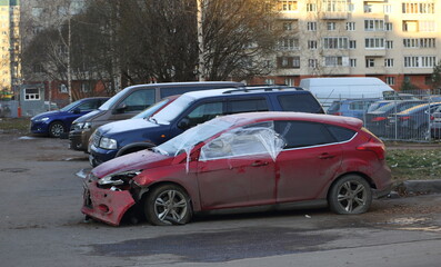 A broken red car is parked on the street, Iskrovsky Prospekt, St. Petersburg, Russia, December 2022