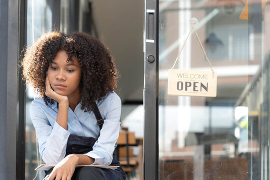 Black Woman Waiter Of Street Cafe Is Waiting For Clients, Customersm She Is Bored, No People In Their Cafe. Small Business Owner.