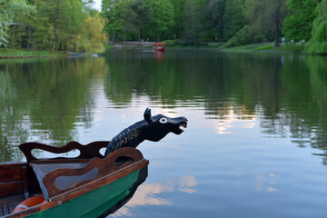 Wooden carved boat on the background of the lake