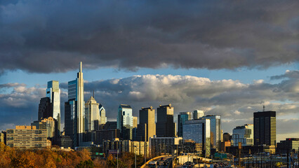 Obraz premium Skyline of Philadelphia (PA) USA at sunset under dark clouds, with copy space.