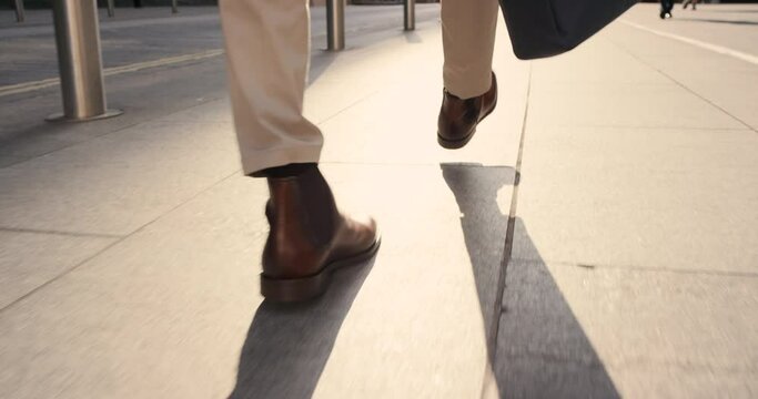 Shoes, walking and city with a business man on his morning commute in work with motivation for success. Zoom, sidewalk and following with a male employee commuting by foot during a walk in town