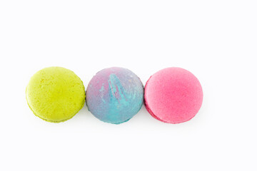 Brightly colored French macarons, white background. Tasty colorful macaroon assorted. Three sweet macaroons cakes. Pastry made from egg whites. Concept of food, desserts. Culinary and cooking concept.