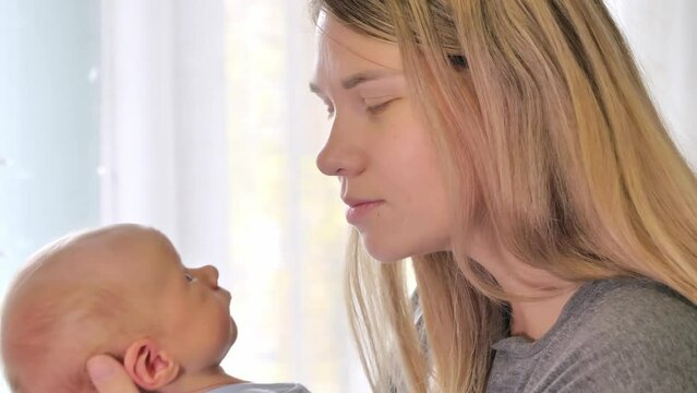 Mom kissing her newborn baby. Love and tenderness. Family concept. Slow motion shot